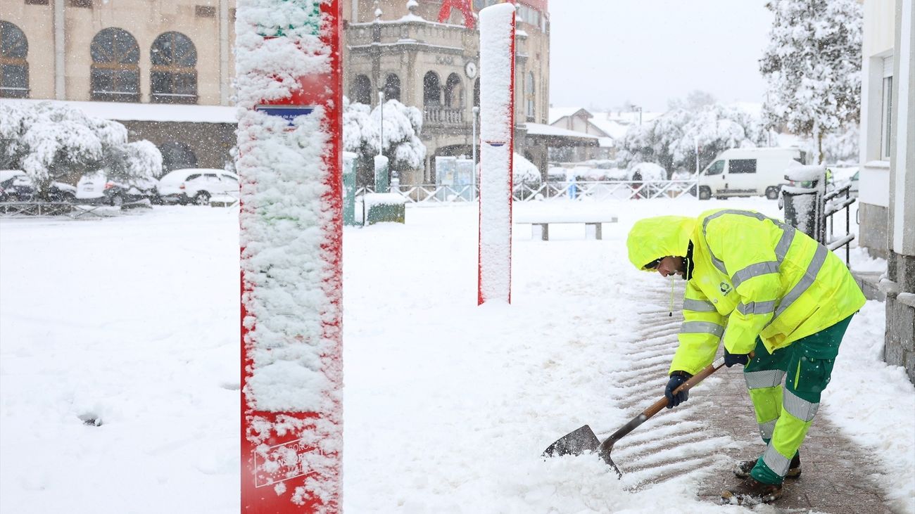 Un trabajador retira la nieve de una parada de autobús