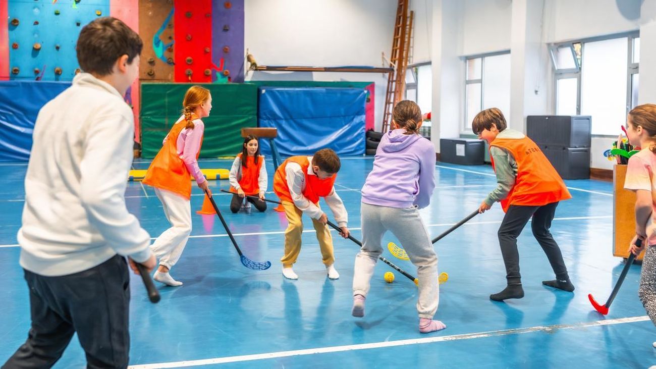 Niños jugando al hockey en un colegio