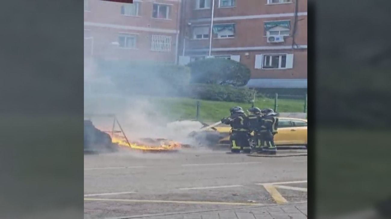 Un coche gravemente afectado por el incendio de dos contenedores en Aluche