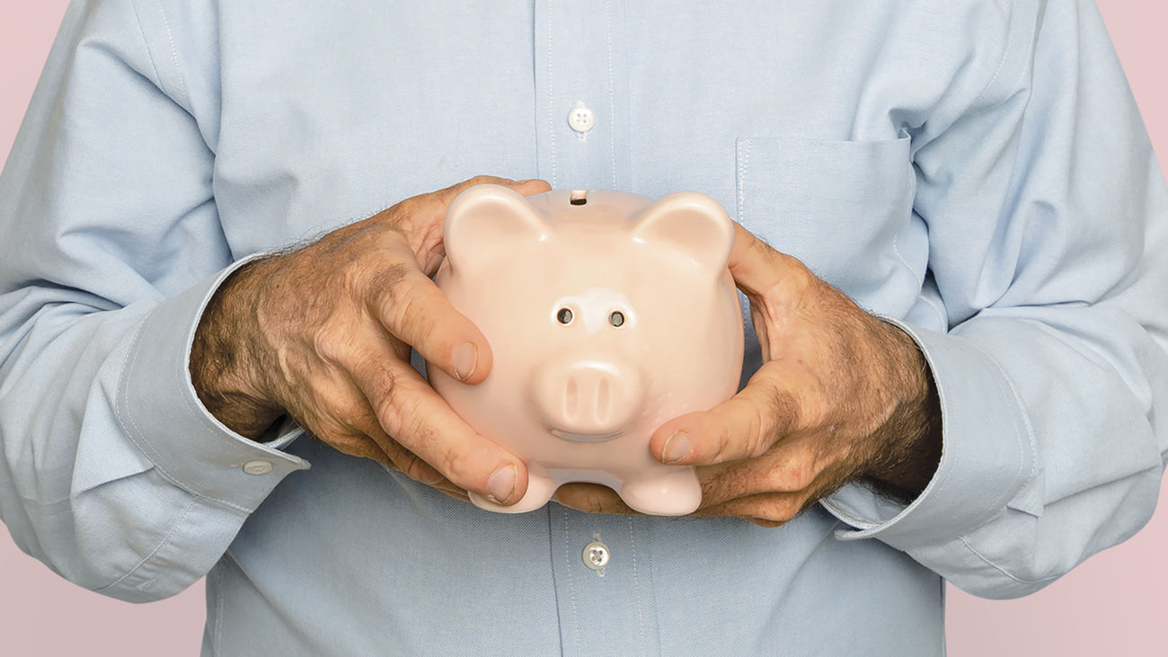 Hombre mayor sosteniendo una hucha