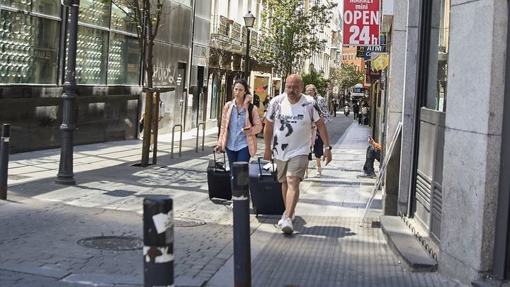 Turistas con maletas por el barrio de Chueca