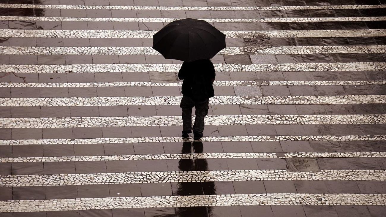 Persona caminando por la calle con un paraguas
