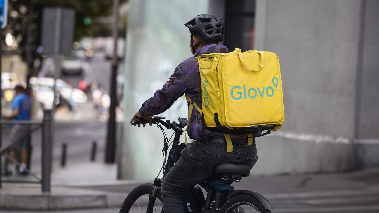 Un repartidor de Glovo en bicicleta por una calle de Madrid