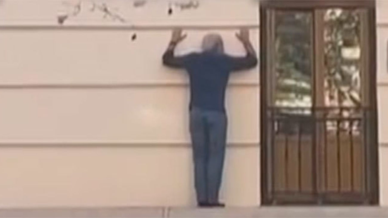 Se hace un 'spiderman' imprudente en plena calle Princesa para entrar en su casa