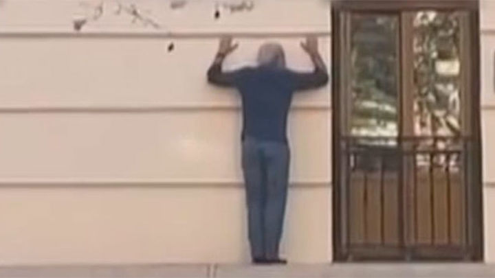 Se hace un 'spiderman' imprudente en plena calle Princesa para entrar en su casa