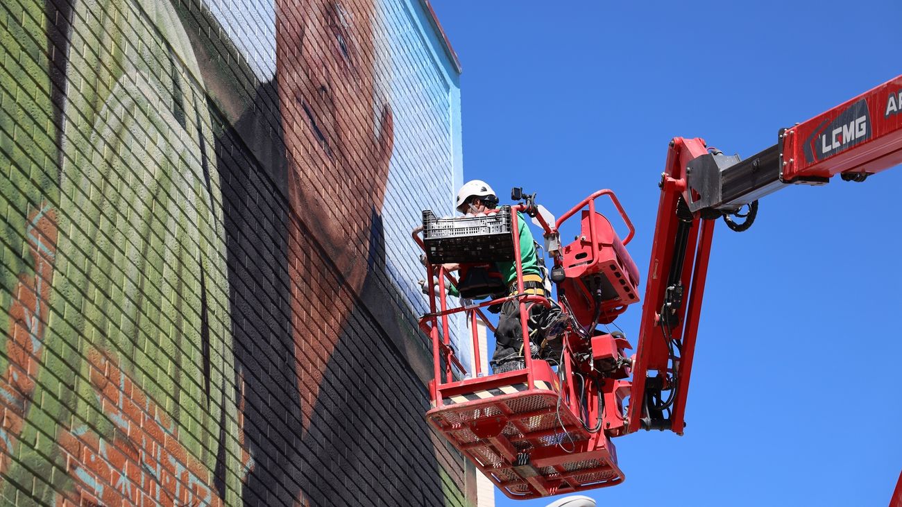 El artista Christian Sasa, durante la elaboración del mural 'Manos de Acero' en Fuenlabrada