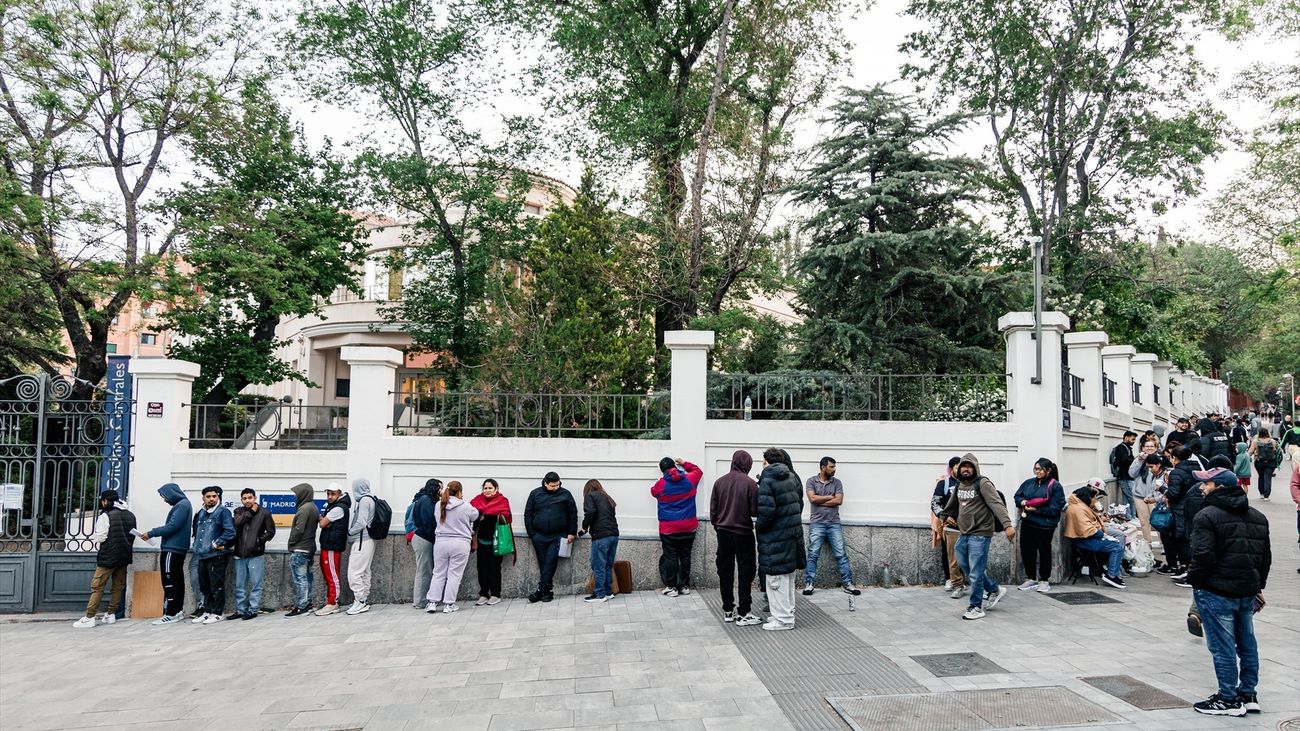 Personas hacen cola para conseguir el certificado de vulnerabilidad en una Oficina de Asistencia en Materia de Registro, en Madrid