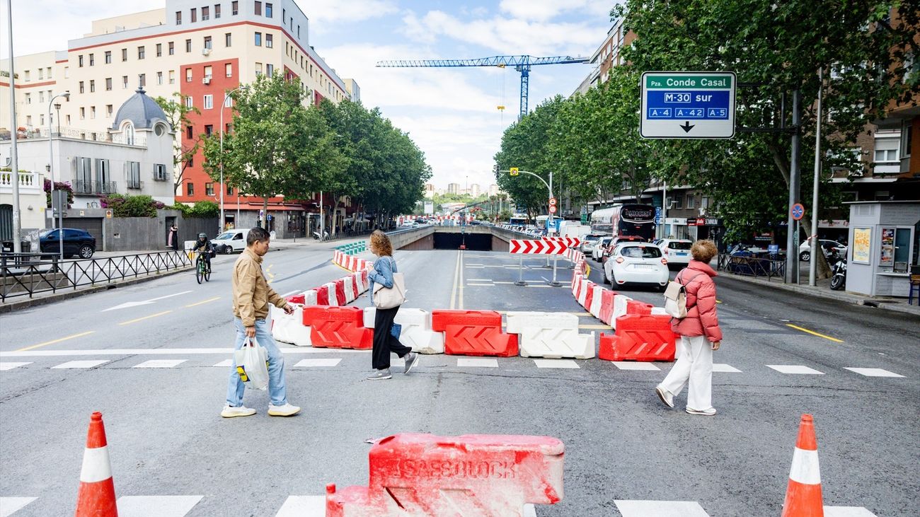 Varias personas cruzan la calle en la zona de obra de la Plaza de Conde de Casal