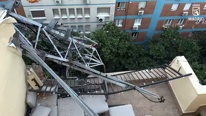 Los bomberos retiran una antena de 20 metros que cayó sobre la cubierta de un edificio en Madrid