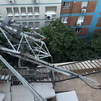 Los bomberos retiran una antena de 20 metros que cayó sobre la cubierta de un edificio en Madrid