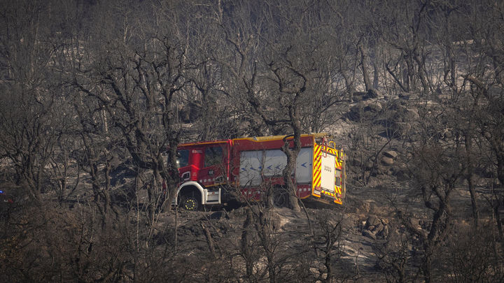 Un camión de bomberos cruza una zona arrasada por las llamas del incendio forestal en La Bisbal de l'Empordà (Girona)