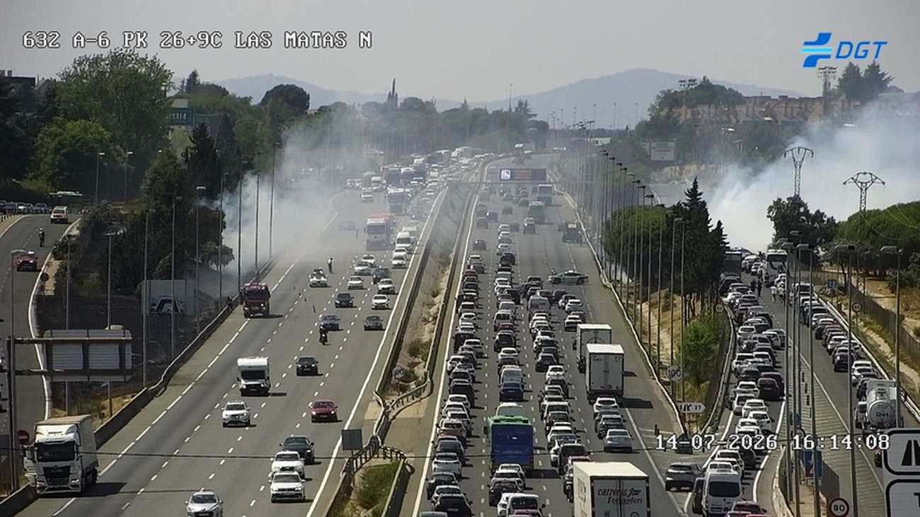 Humo sobre la A-6 cortada parcialmente en el kilómetro 27, en Torrelodones, por un incendio en la cuneta