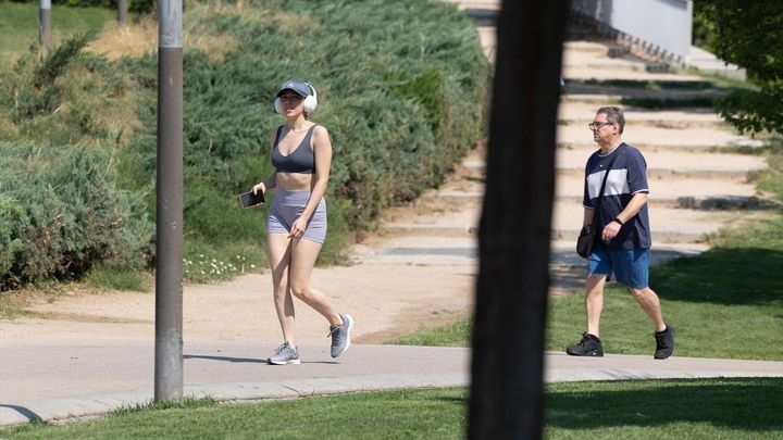 Varias personas pasean en un parque en Madrid