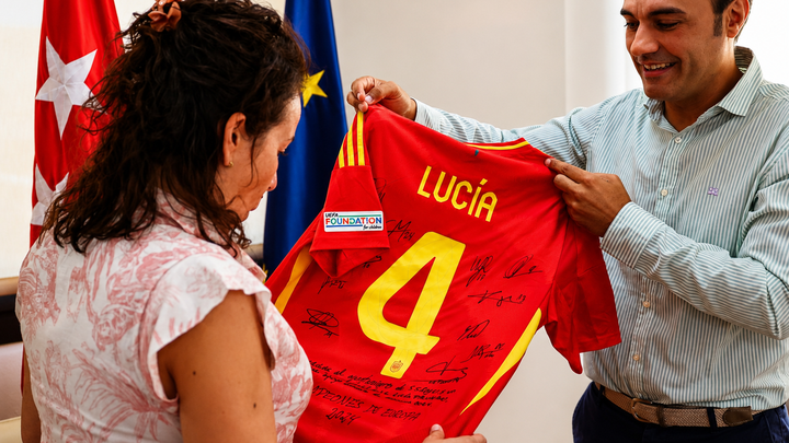 Benito Milano, fisioterapeuta de la Selección Española, entrega una camiseta a la alcaldesa de San Sebastián de los Reyes