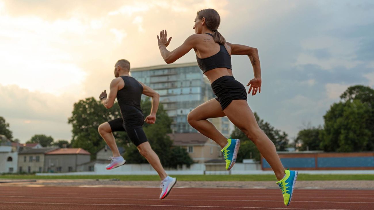 Un hombre y una mujer corriendo en una pista de atletismo