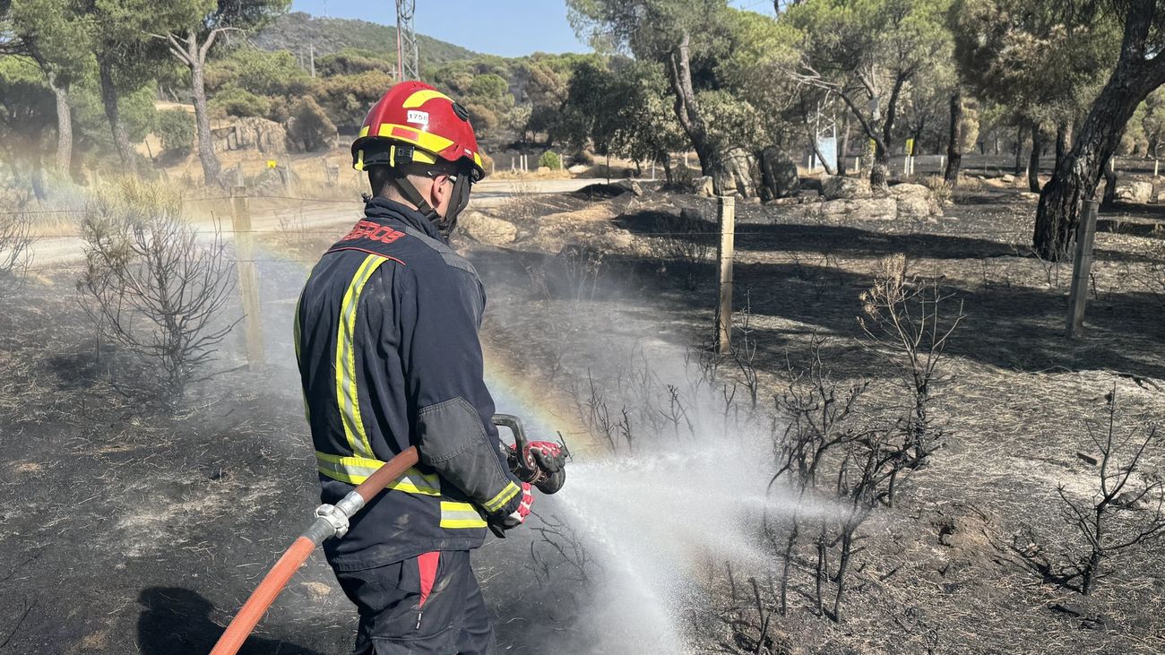 Una veintena de dotaciones mantienen sin reproducciones el incendio de la sierra madrileña durante la noche