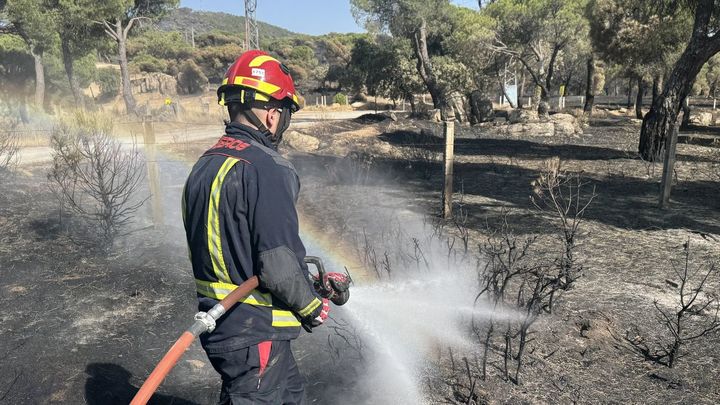 Una veintena de dotaciones mantienen sin reproducciones el incendio de la sierra madrileña durante la noche