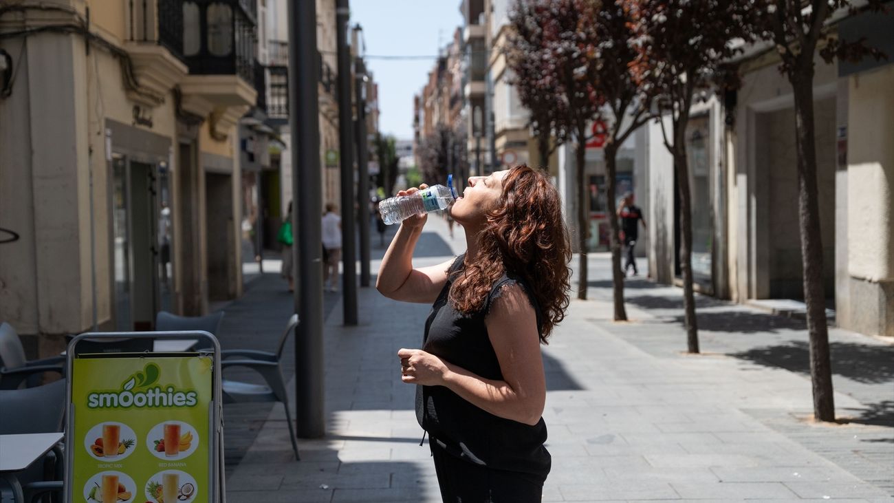 Mujer bebiendo agua en una calle de Madrid