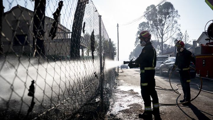 Un bombero refresca la zona de Aldea del Fresno afectada por el incendio