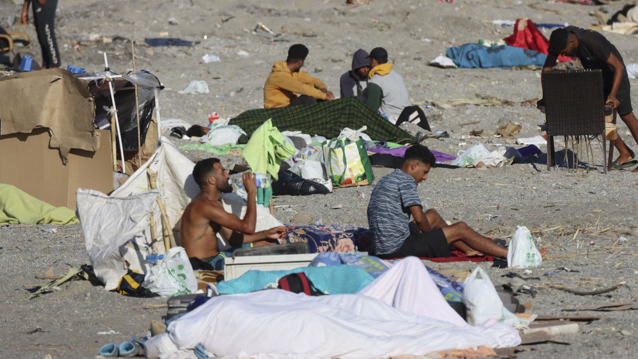Varios migrantes permanecen acampados este sábado, en la playa El Trampolín de Ceuta