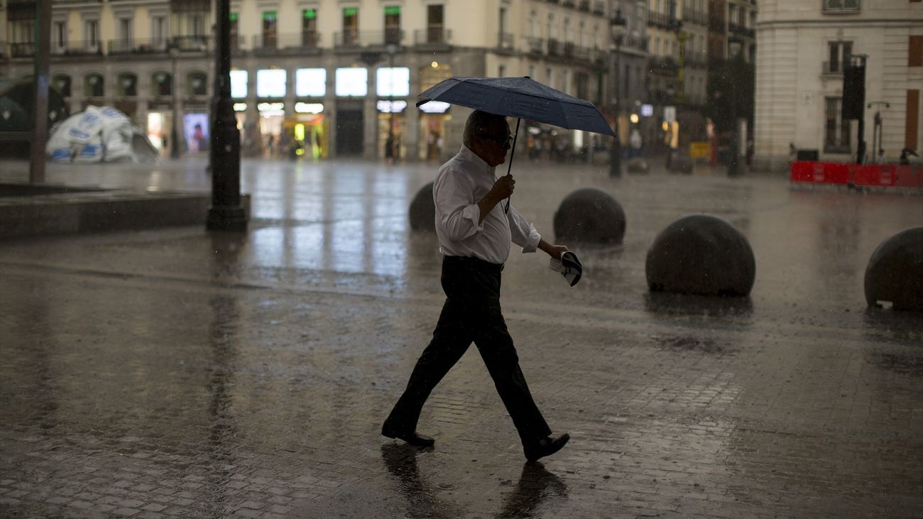 Hombre con paraguas por la calle de Madrid