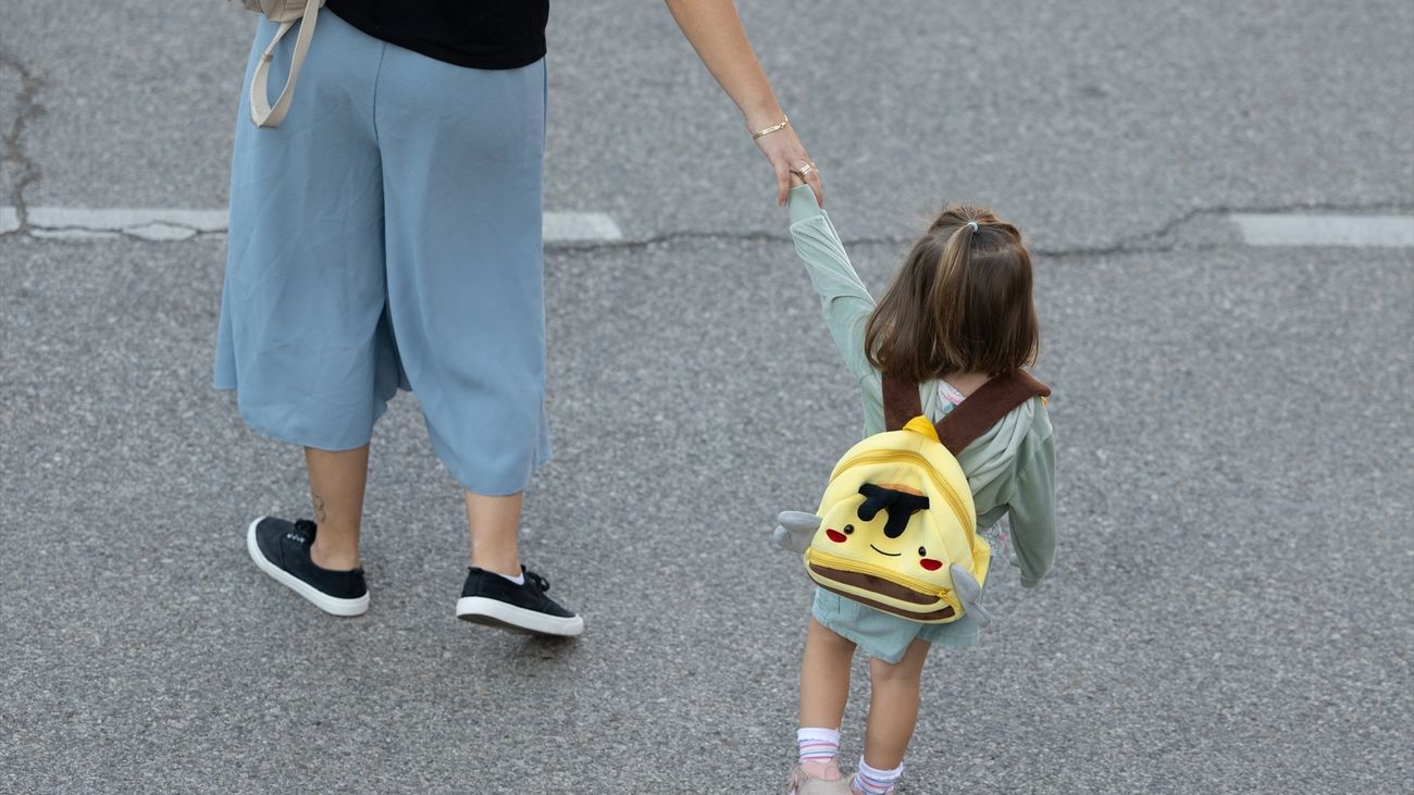 Una niña de infantil se dirige con su madre al colegio