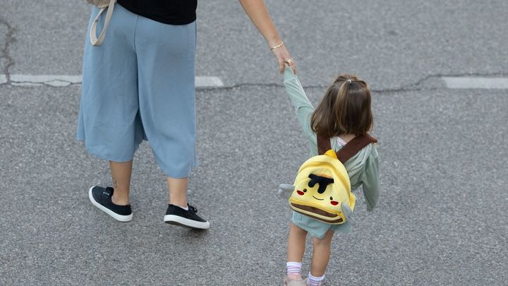 Una niña de infantil se dirige con su madre al colegio