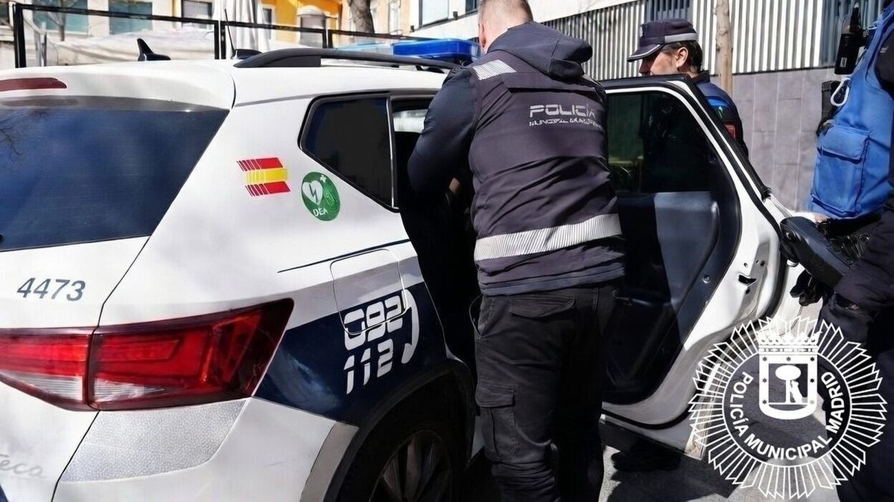 Agentes de la Policía Municipal de Madrid junto a un coche patrulla